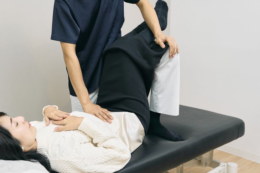 お腹まわりに手を添えて整える施術