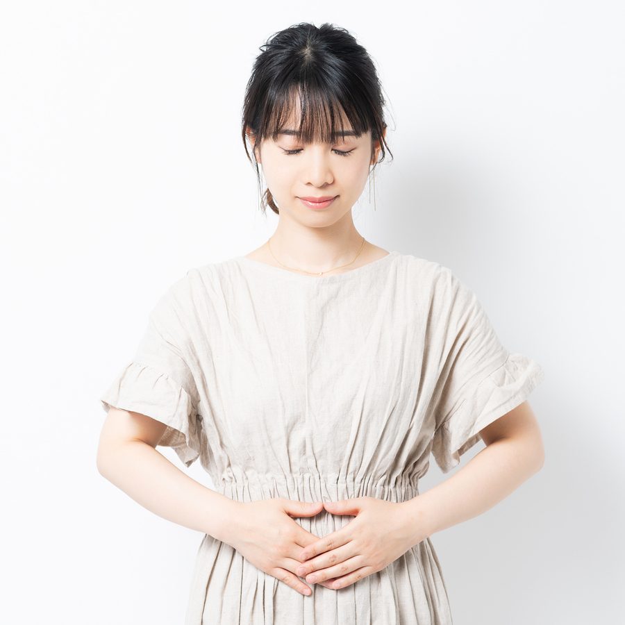 お腹に手を当てる女性